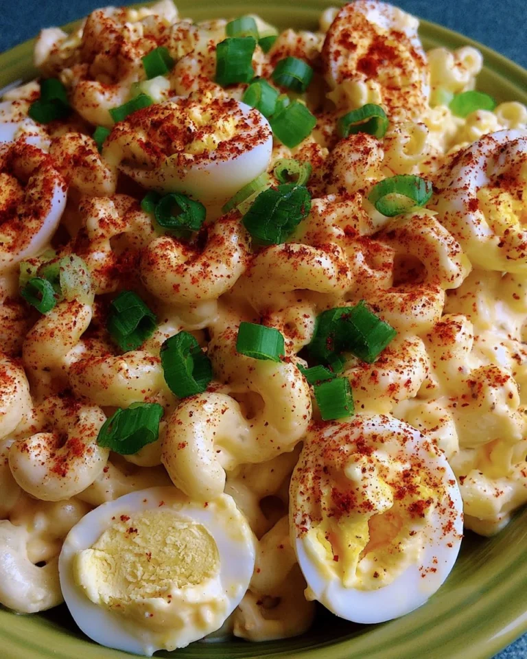 Bowl of deviled egg pasta salad garnished with herbs and spices